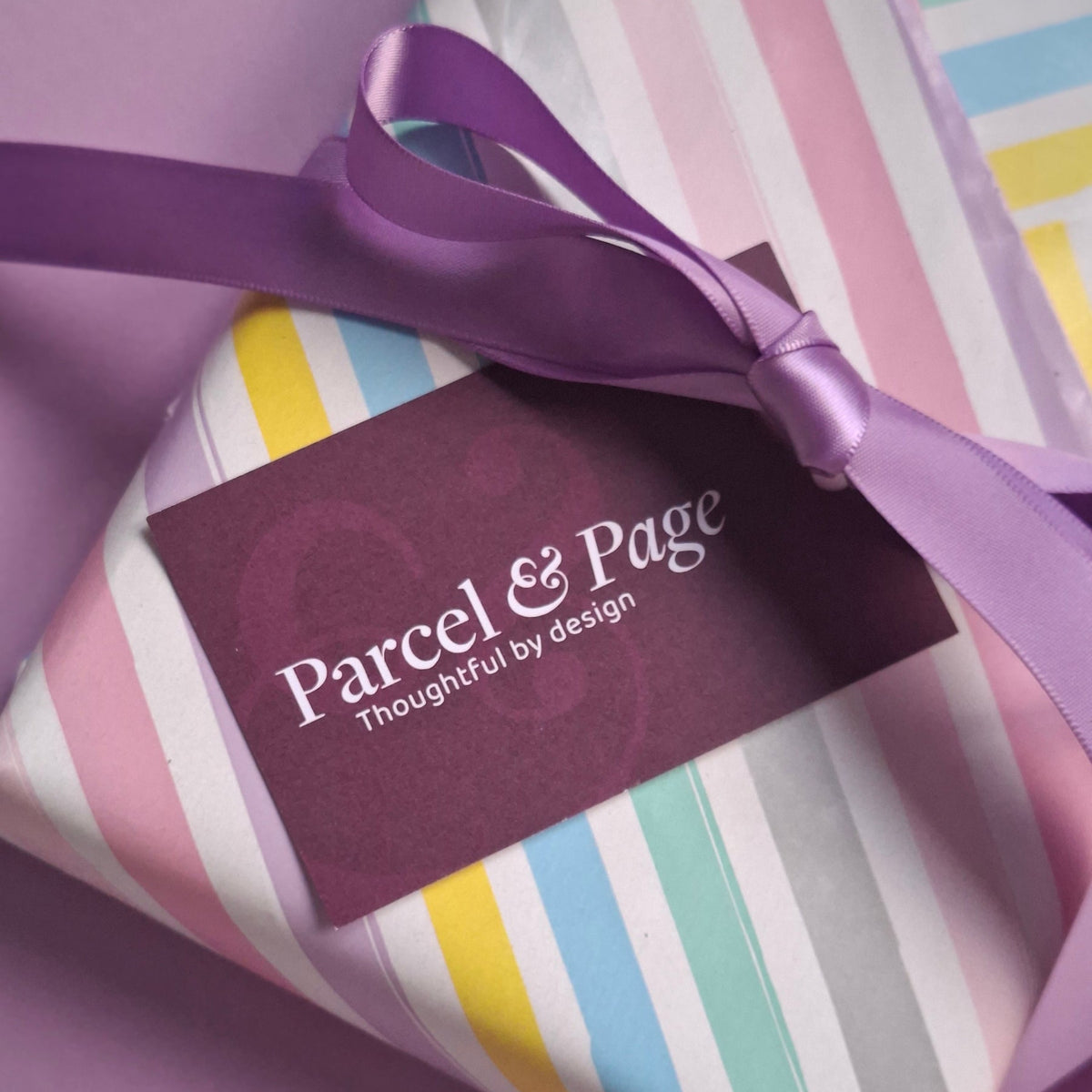 Gift wrapped in striped paper with a purple ribbon and Parcel & Page label.